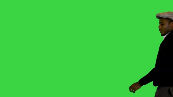 Fiatal jóképű fekete srác kalapban sétál a zöld vásznon, Chroma Key. — Stock videók