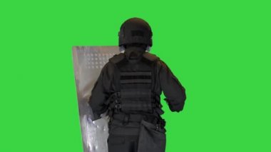Çevik kuvvet polisi elinde bir kalkan ve sopayla Yeşil Ekran 'da koşuyor, Chroma Key.