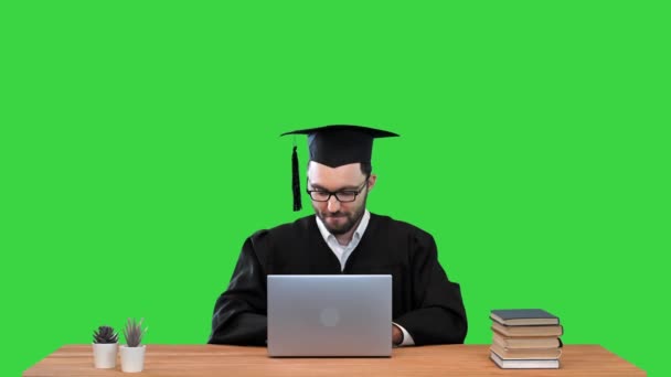Ευτυχισμένος χαμογελαστός απόφοιτος φοιτητής κλείνει φορητό υπολογιστή και γιορτάζει το τέλος της έρευνάς του σε μια πράσινη οθόνη, Chroma Key. — Αρχείο Βίντεο