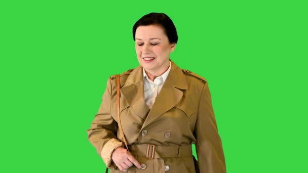 Mulher morena grossa em um casaco de trincheira andando em uma tela verde, Chroma Key. — Vídeo de Stock