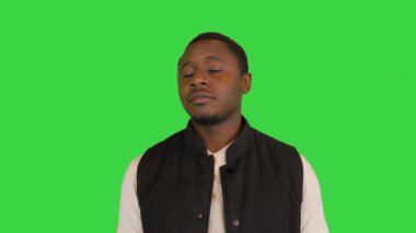 Mutlu Afrikalı Amerikalı adam güneş gözlüğünü takıyor ve yeşil ekranda gülümsüyor, Chroma Key..