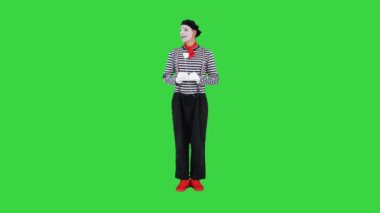 Yeşil Ekran 'da kağıt gül çiçeği tutan pandomimci, Chroma Key.