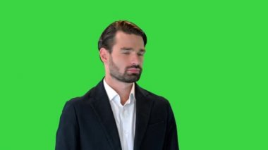 Yakışıklı genç adam yeşil ekranda dururken sana gülümseyerek göz kırpıyor, Chroma Key.