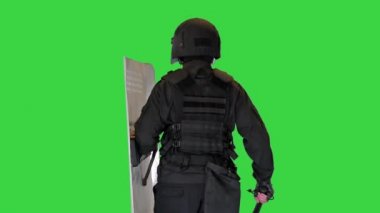 Çevik kuvvet birimi yeşil ekranda bir kalkan ve sopayla yürüyor, Chroma Key.