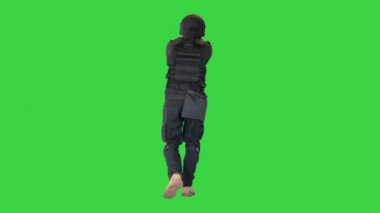 Silahlı Polis Memuru Yeşil Ekran 'da yürürken tabancayla nişan alıyor ve ateş ediyor, Chroma Key.