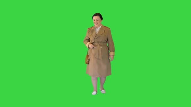 크로마 키, 그린 스크린 위를 걷고 있는 해구 코트를 입고 있는 질긴 갈색 머리 여자. — 비디오