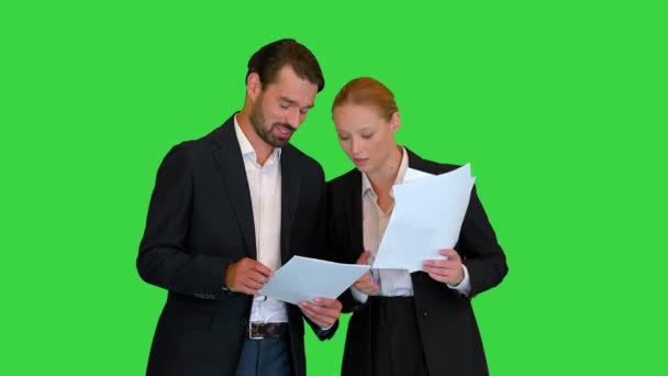 Två unga affärsmän talar om dokument på en grön skärm, Chroma Key. — Stockvideo