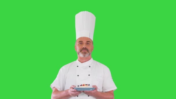Одягнений кухар-кухар робить смачний жест з десертом в руках на зеленому скринінгу, Chroma Key. — стокове відео