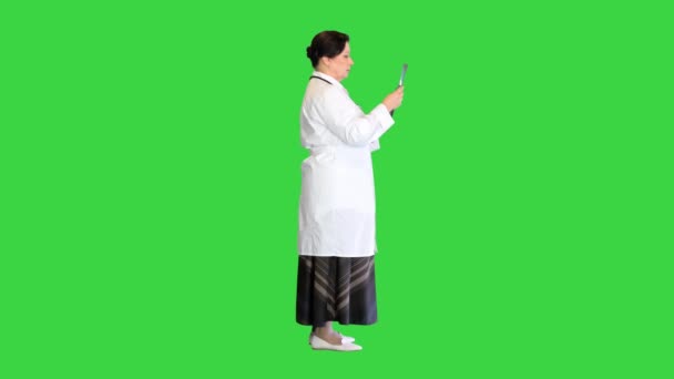 Зрелая женщина-врач осматривает пациентов рентгеном на зеленом экране, хрома ключ. — стоковое видео