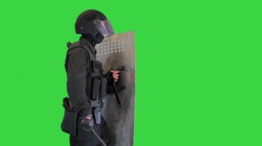 Zırhlı ağır bir polis, kalkanı ve bastonu var. Yeşil Ekran 'da yürüyor, Chroma Key..