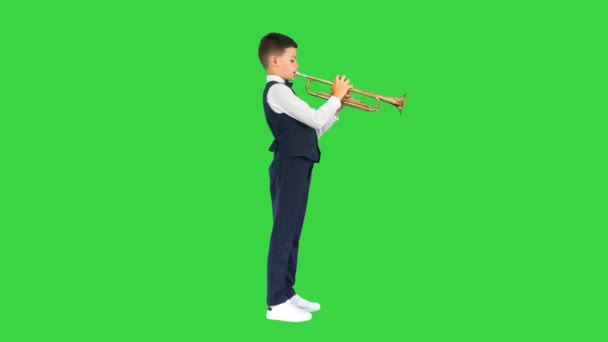 Konzentrierter kleiner Junge in Fliege, der die Trompete auf einem Green Screen bläst, Chroma Key. — Stockvideo
