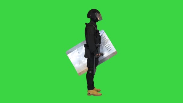 Policeman in full riot gear standing with the shield down on a Green Screen, Chroma Key. — Stock Video
