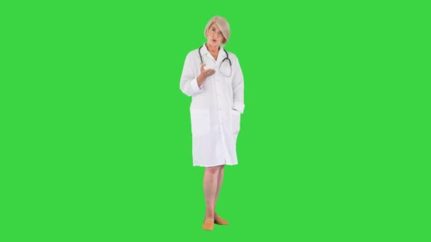 緑の画面でカメラに話している快適な携帯医師の女性,クロマキー. — ストック動画