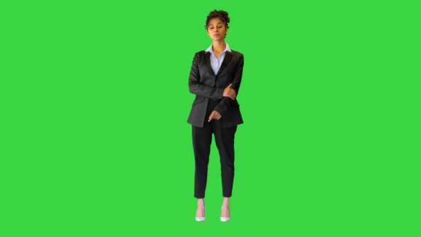 Χαρούμενη μαύρη κυρία προσαρμόζοντας το σακάκι της και κοιτάζοντας στην κάμερα σε μια πράσινη οθόνη, Chroma Key. — Αρχείο Βίντεο