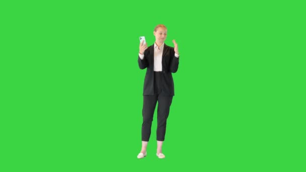 Νεαρή γυναίκα κάνει μια βιντεοκλήση με το smartphone της σε μια πράσινη οθόνη, Chroma Key. — Αρχείο Βίντεο