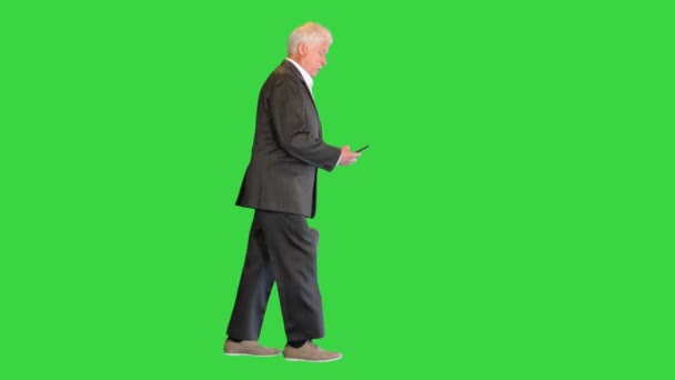 Senior affärsman promenader och ringa ett samtal på en grön skärm, Chroma Key. — Stockvideo