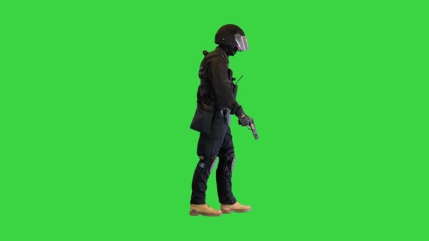 Luchador antiterrorista caminando con una pistola en una mano en una pantalla verde, Chroma Key. — Vídeo de stock