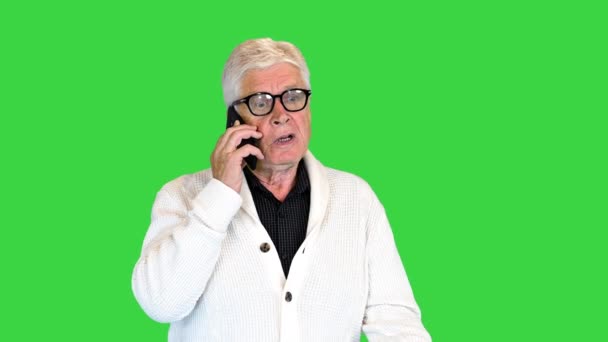Boos senior man maakt een oproep op een groen scherm, Chroma Key. — Stockvideo