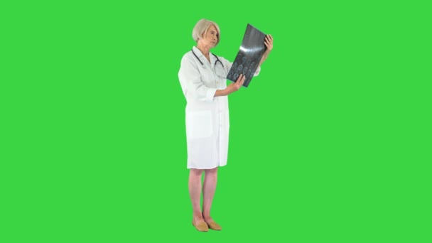 Specialist feminin verificarea rezultatelor tomografiei cerebrale pe un ecran verde, Chroma Key . — Videoclip de stoc