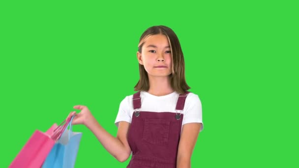 Pretty asian girl with colorful shopping bags on a Green Screen, Chroma Key. — Stock Video