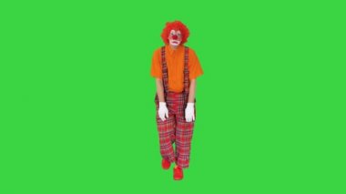 Üzgün, mutsuz palyaço Yeşil Ekran 'da komik bir şekilde yürüyor, Chroma Key.