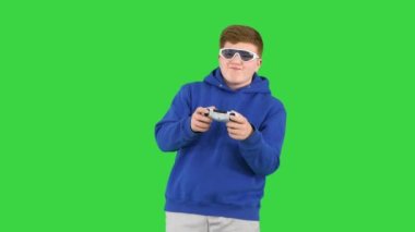Yeşil Ekran, Chroma Key 'de güneş gözlükleriyle video oyunu oynayan havalı modern çocuk..