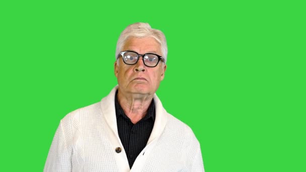 Happy aged man shows a greeting sign on a Green Screen, Chroma Key. — Stock Video