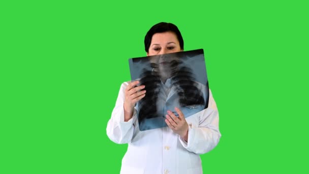 Зріла жінка - лікар обстежує пацієнтів рентгенівським променем на зеленому екрані (Chroma Key).. — стокове відео