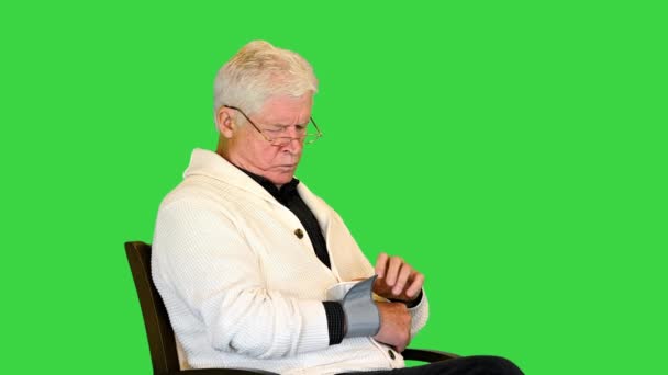 L'uomo anziano si sente male misurando la pressione sanguigna su uno schermo verde, chiave cromatica. — Video Stock