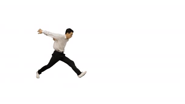Ung man klädd i vit skjorta och svarta byxor dans break-dance och ler mot kameran i slutet på vit bakgrund. — Stockvideo