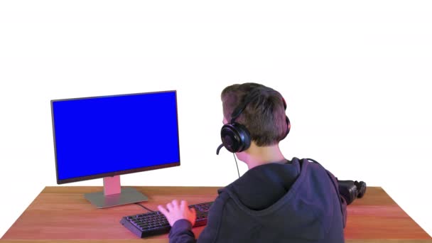 Rekabetçi genç adamın beyaz arka planda bilgisayarda oynadığı online oyunların arka planı. — Stok video
