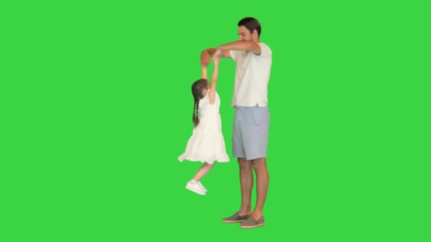 Счастливый папа поднимает свою маленькую дочь на зеленый экран, хрома ключ. — стоковое видео