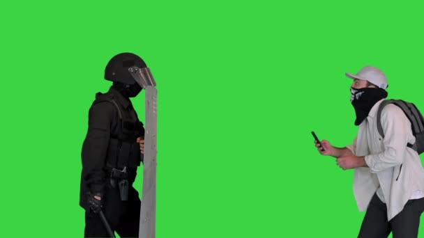 Aggressiv protesterare skytte upplopp polis på smartphone på en grön skärm, Chroma Key. — Stockvideo