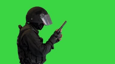 Korumalı namlulu silahlı bir adam yeşil ekrana nişan alarak yürüyor, Chroma Key..