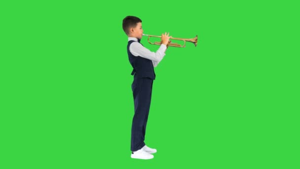 一个打着蝴蝶结领带的小男孩在绿色屏幕上吹喇叭，铬键. — 图库视频影像