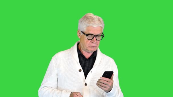 Довольный старик, использующий свой смартфон на Зеленом экране, Chroma Key. — стоковое видео