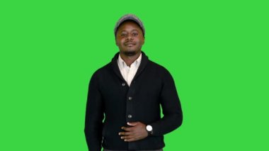 Yakışıklı siyah adam yeşil ekranda kameraya gülümsüyor, Chroma Key.