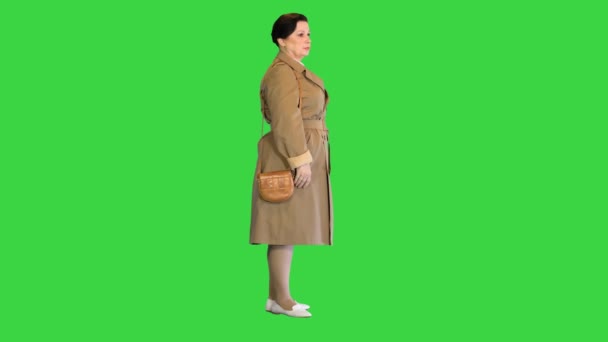 Середньолітня жінка в траншеї стоячи на зеленому екрані, Chroma Key. — стокове відео