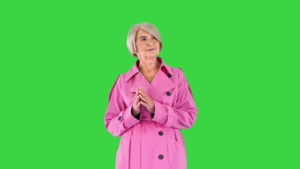 Slimme dame in roze trench jas staan, wachten en denken op een groen scherm, Chroma Key. — Stockvideo