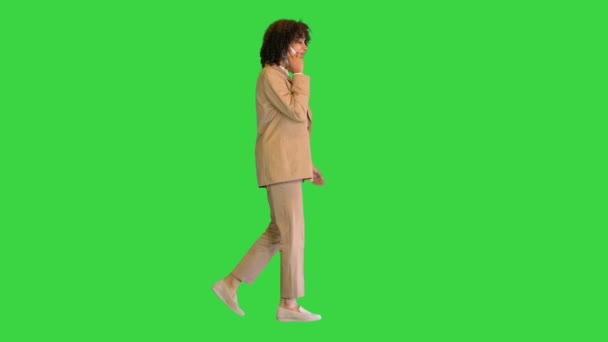 Fille aux cheveux bouclés noire marchant et parlant au téléphone sur un écran vert, Chroma Key. — Video