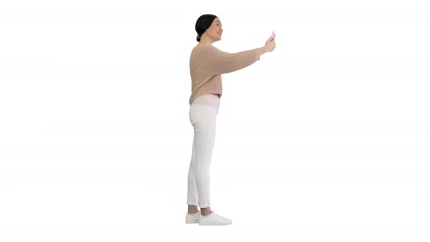 Usmívající se mladá žena s videohovor na telefonu mává rukou na bílém pozadí. — Stock video