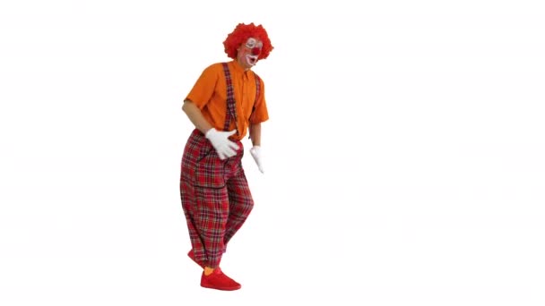 Funny clown walking and looking back sometimes on white background. — Stock Video