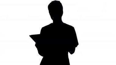 Siluet Genç kadın doktor ya da önlüklü hemşire yürürken dokunmatik ekran bilgisayar kullanıyor..