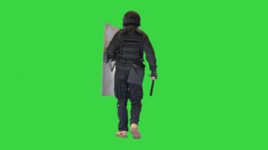 Çevik kuvvet birimi yeşil ekranda bir kalkan ve sopayla yürüyor, Chroma Key.