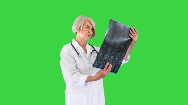 Spécialiste féminin vérifiant les résultats de la tomographie cérébrale sur un écran vert, Chroma Key. — Video