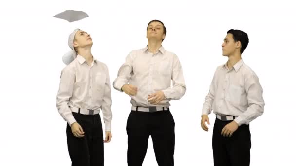 Trzech facetów rzuca dokumentami w powietrze i zaczyna zabawnie tańczyć na białym tle. — Wideo stockowe