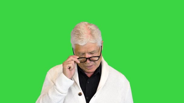 本当に疲れて灰色の髪のシニアビジネスの男は、緑の画面、クロマキーで眼鏡を取る. — ストック動画