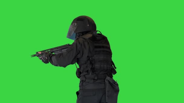 Maskovaný ozbrojený policista SWAT kráčí a míří puškou na zelenou obrazovku, Chroma Key. — Stock video