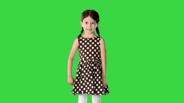 かわいいです女の子でポルカドットドレス何かについて話している緑の画面上のカメラ,クロマキー. — ストック動画