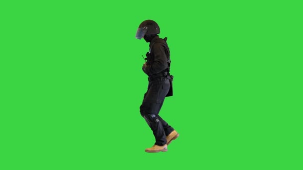 Bereitschaftspolizist im Helm beim Joggen auf einem Green Screen, Chroma Key.